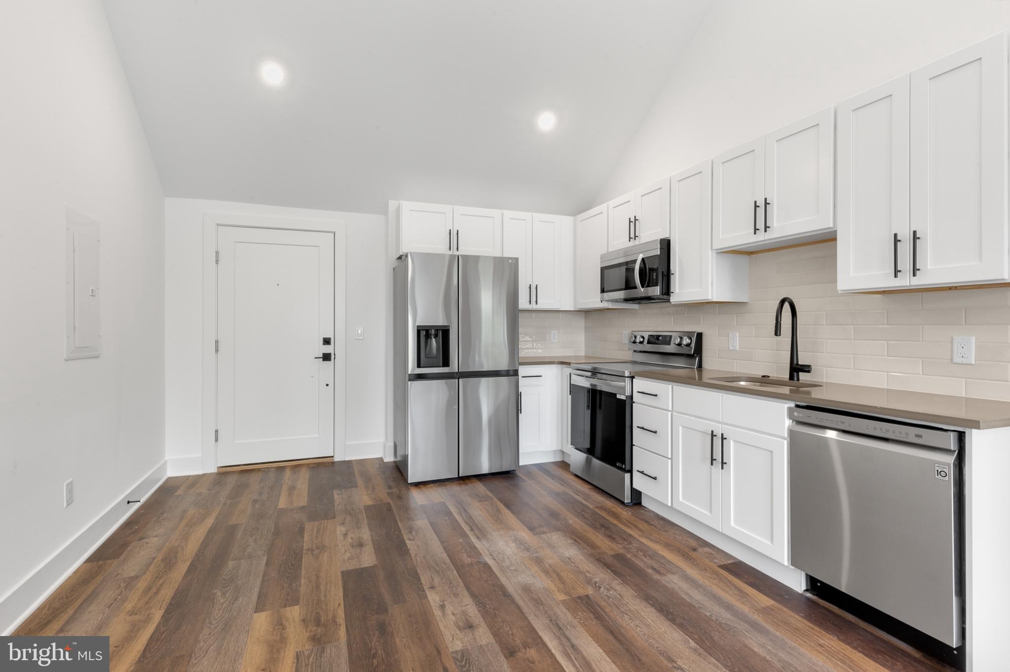 7037 Ridge Avenue, Unit 303 Philadelphia, PA 19128 - Photo 4 of 20 a kitchen with a refrigerator stove top oven and sink