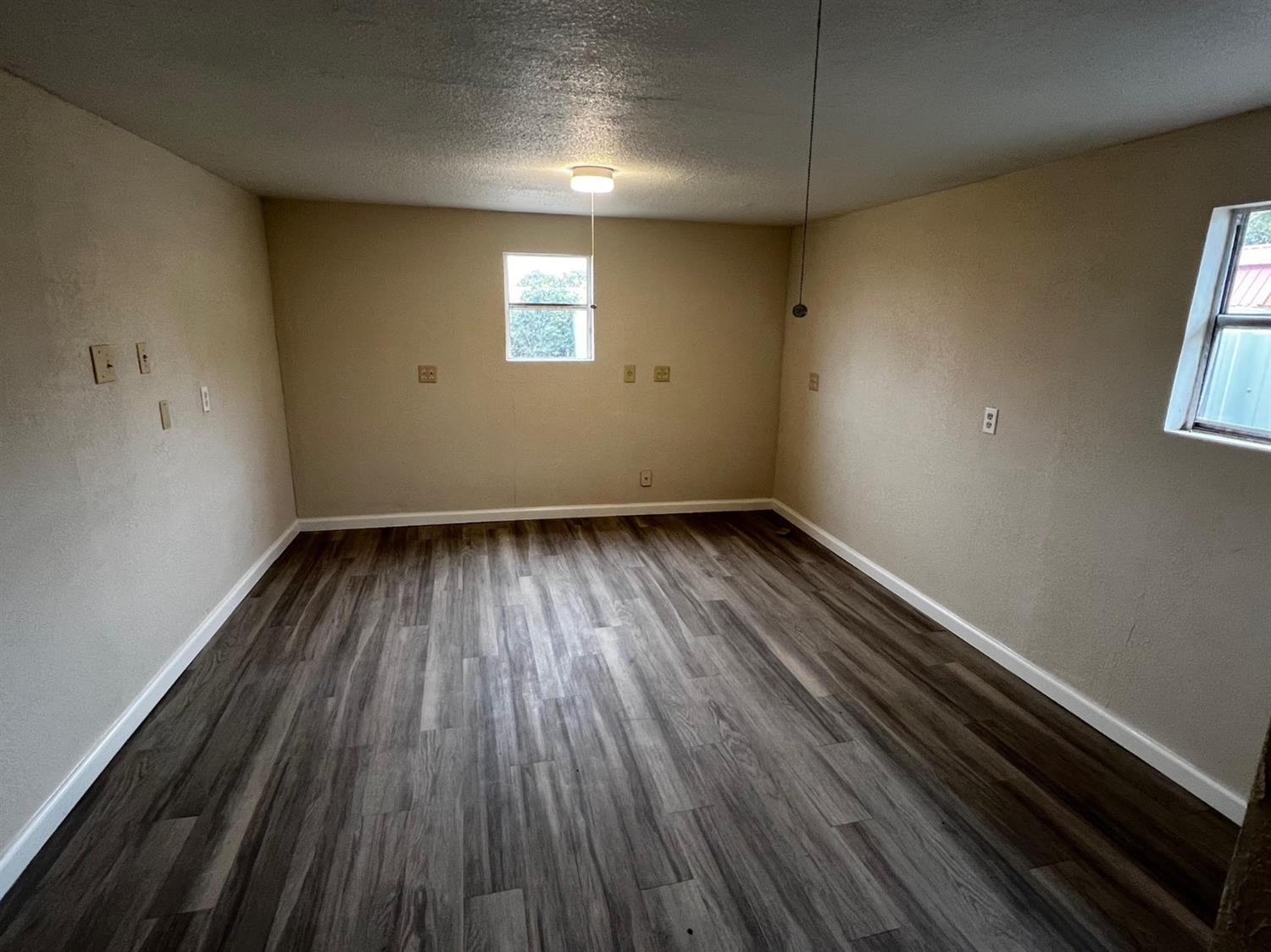 6503 Avenue T Lubbock, TX 79412 - Photo 13 of 15 an empty room with wooden floor and windows
