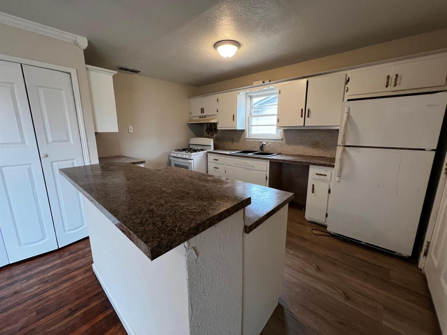6503 Avenue T Lubbock, TX 79412 - Photo 7 of 15 a kitchen with kitchen island a sink a stove a refrigerator and a center island