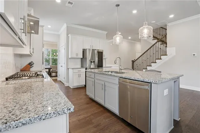 a large kitchen with stainless steel appliances lots of counter space and wooden floor