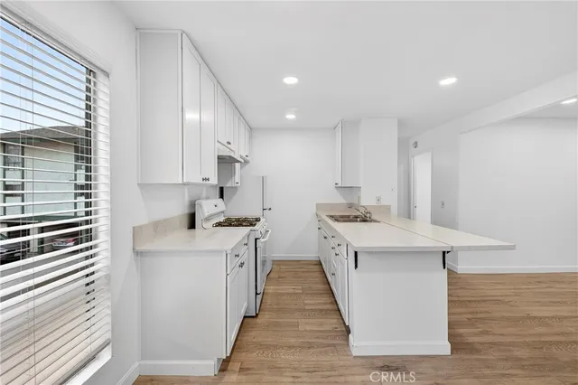 a kitchen with stainless steel appliances a sink stove and cabinets