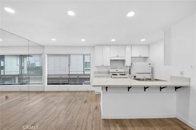 a kitchen with kitchen island sink stove and cabinets
