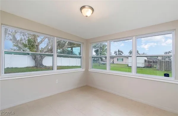 an empty room with wooden floor and a large window