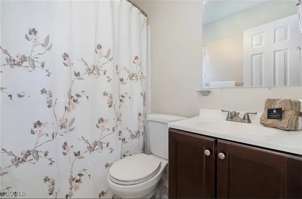 a bathroom with a granite countertop sink a toilet and a shower