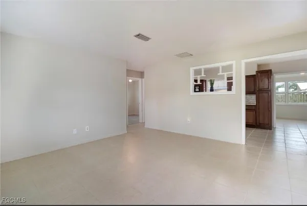 a view of a big room with wooden floor and windows