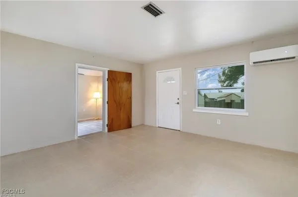 a view of an empty room with window and closet