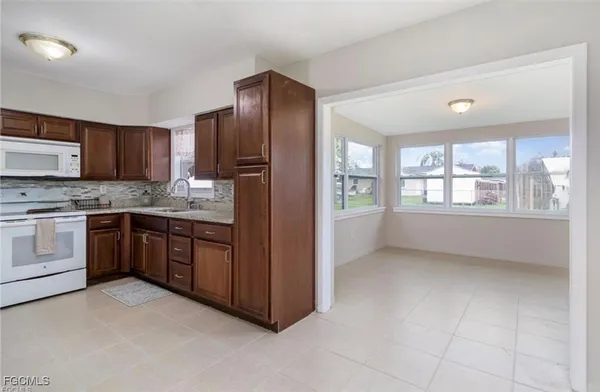 a kitchen with stainless steel appliances kitchen island granite countertop a stove refrigerator and cabinets