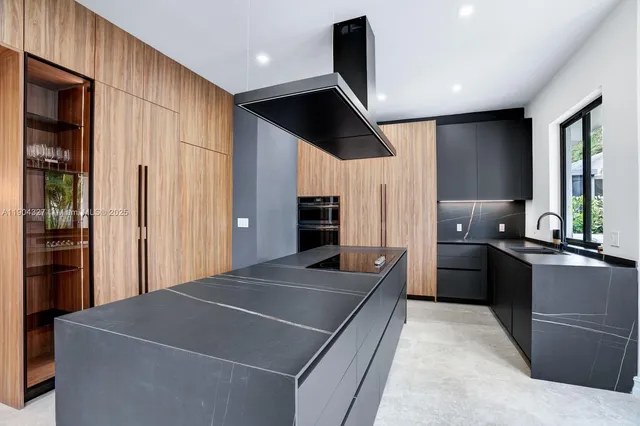 a kitchen with stainless steel appliances kitchen island granite countertop a refrigerator and a sink