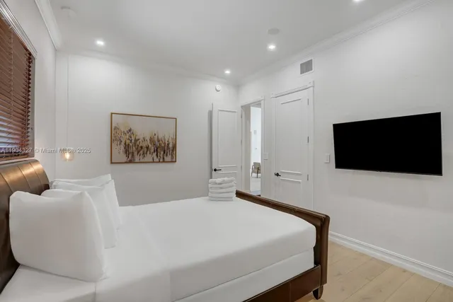 a bedroom with a large bed and a flat screen tv