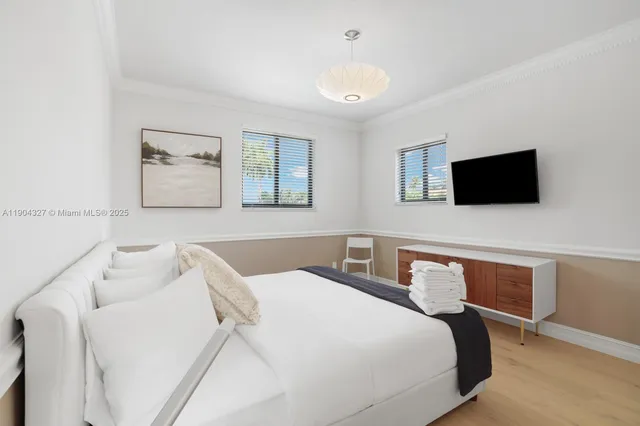 a bedroom with a bed and a flat screen tv