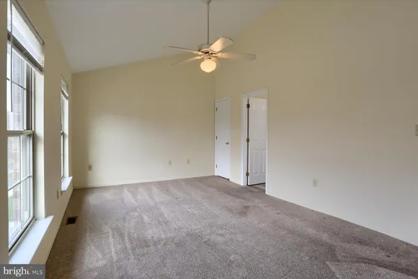 a view of a room with a chandelier fan and windows