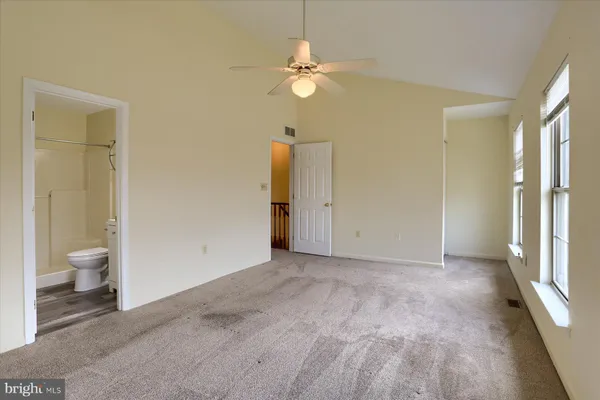 an empty room and a bathroom with toilet