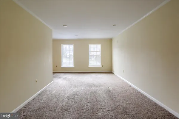 a view of a big room with windows and chandelier fan