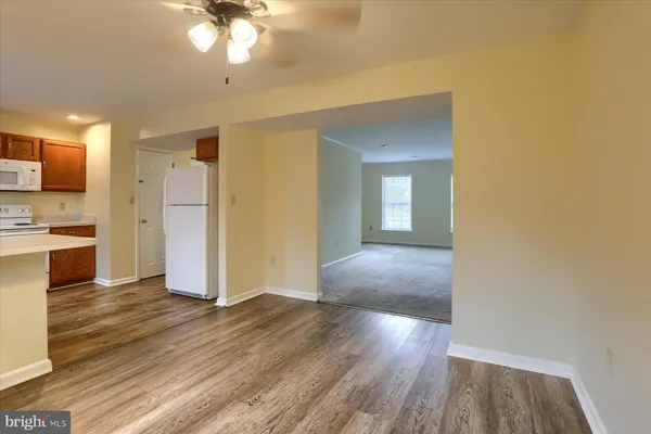 a view of a kitchen with wooden floor and a refrigerator