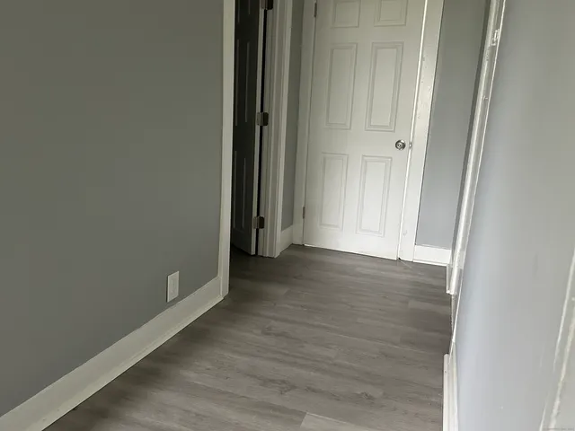 an empty room with wooden floor and door