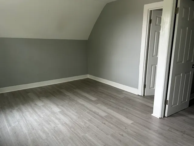 an empty room with wooden floor & closet