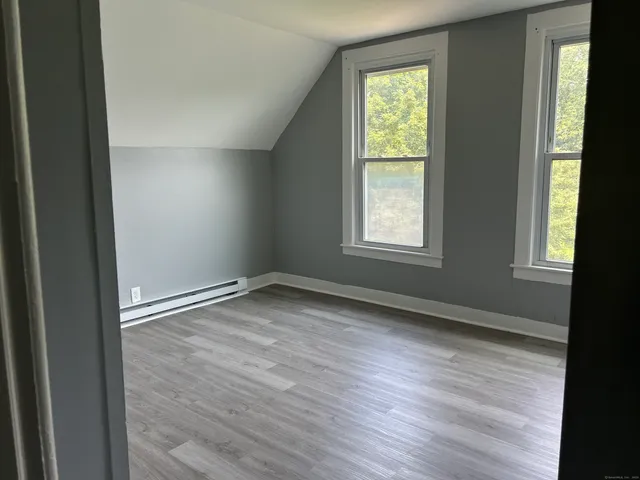 an empty room with wooden floor and closet