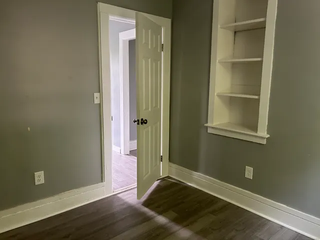 an empty room with wooden floor and closet