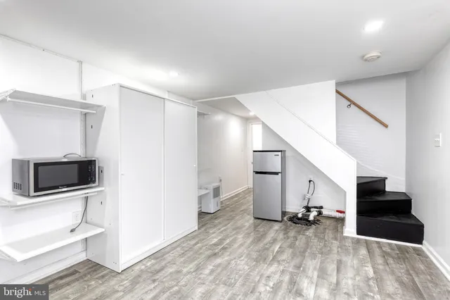 a view of a livingroom with wooden floor and stairs