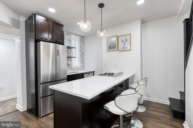 a kitchen with stainless steel appliances a refrigerator and a table