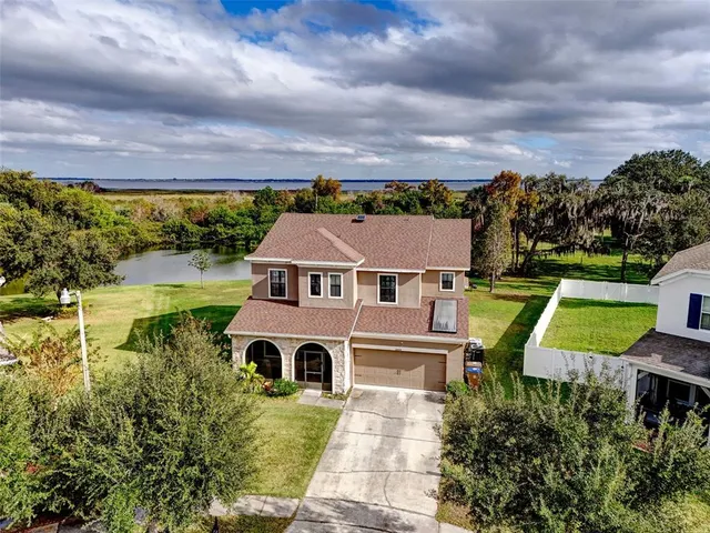 an aerial view of a house with a yard basket ball court and outdoor seating