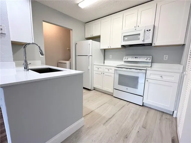 a kitchen with appliances cabinets and a sink