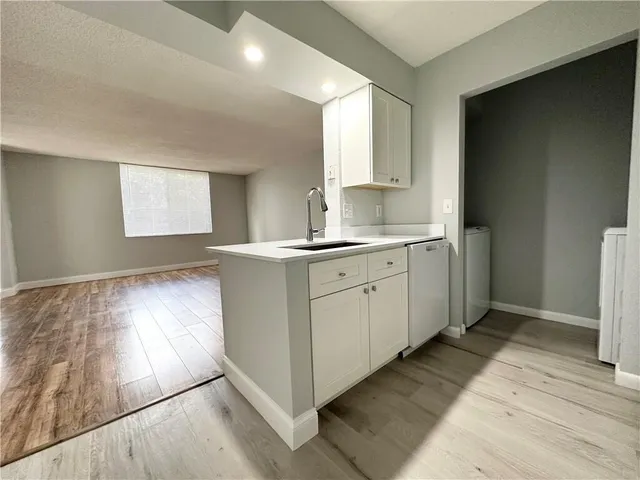 a kitchen with a sink cabinets and wooden floor