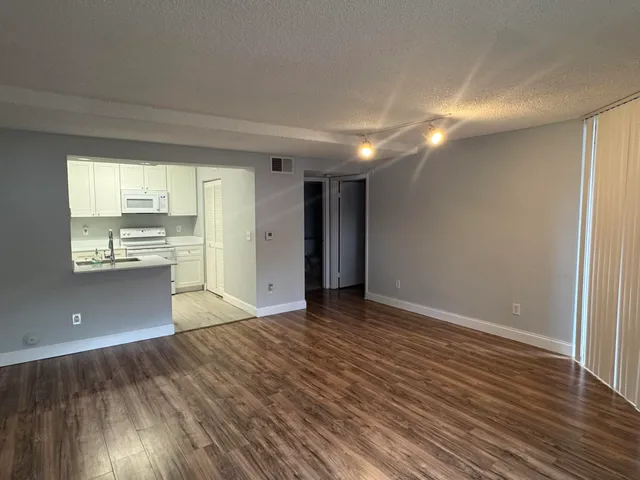 a view of a kitchen with wooden floor and a window