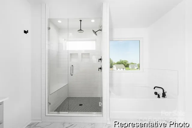 a bathroom with a toilet a sink a glass door a shower and a mirror