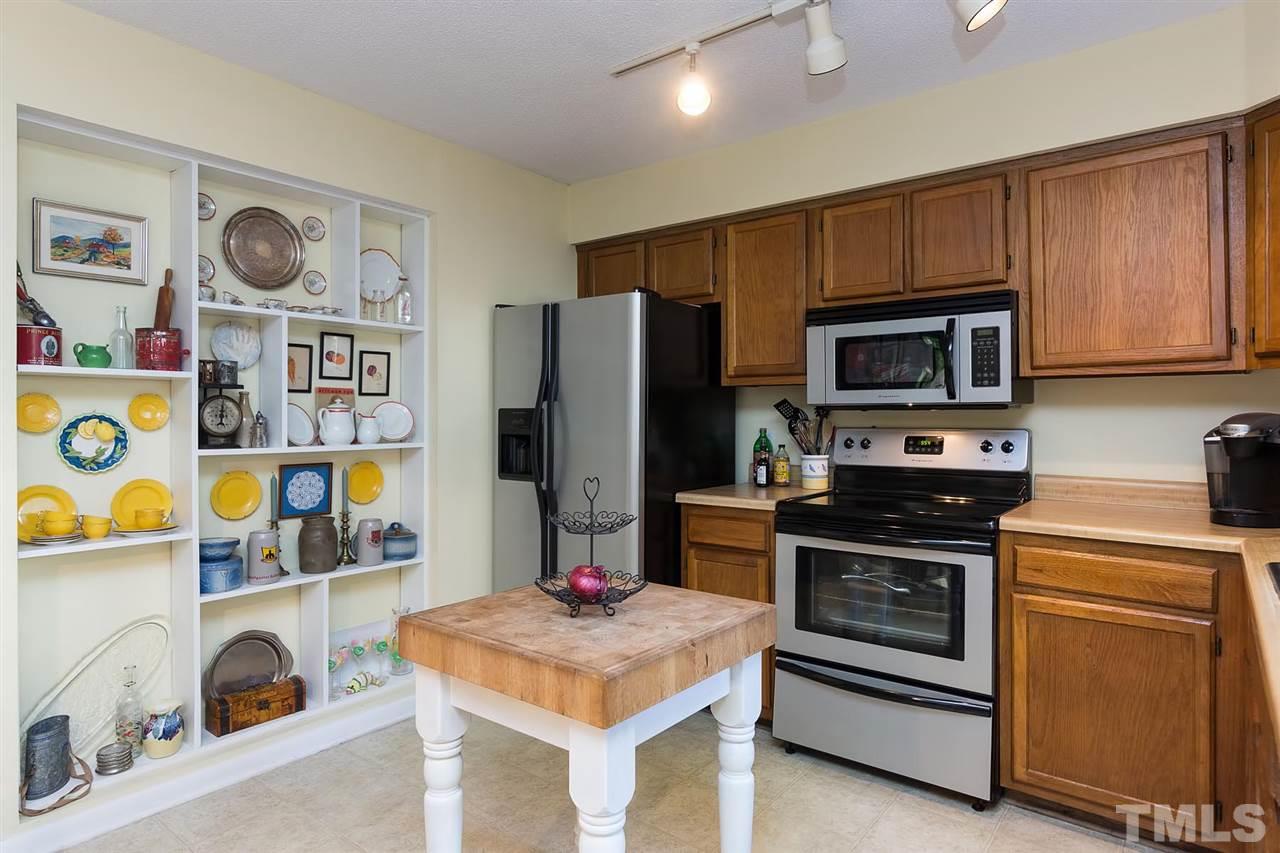 5845 Shady Grove Circle Raleigh, NC 27609 - Photo 7 of 16 a kitchen with stainless steel appliances kitchen island granite countertop a stove a refrigerator and a microwave