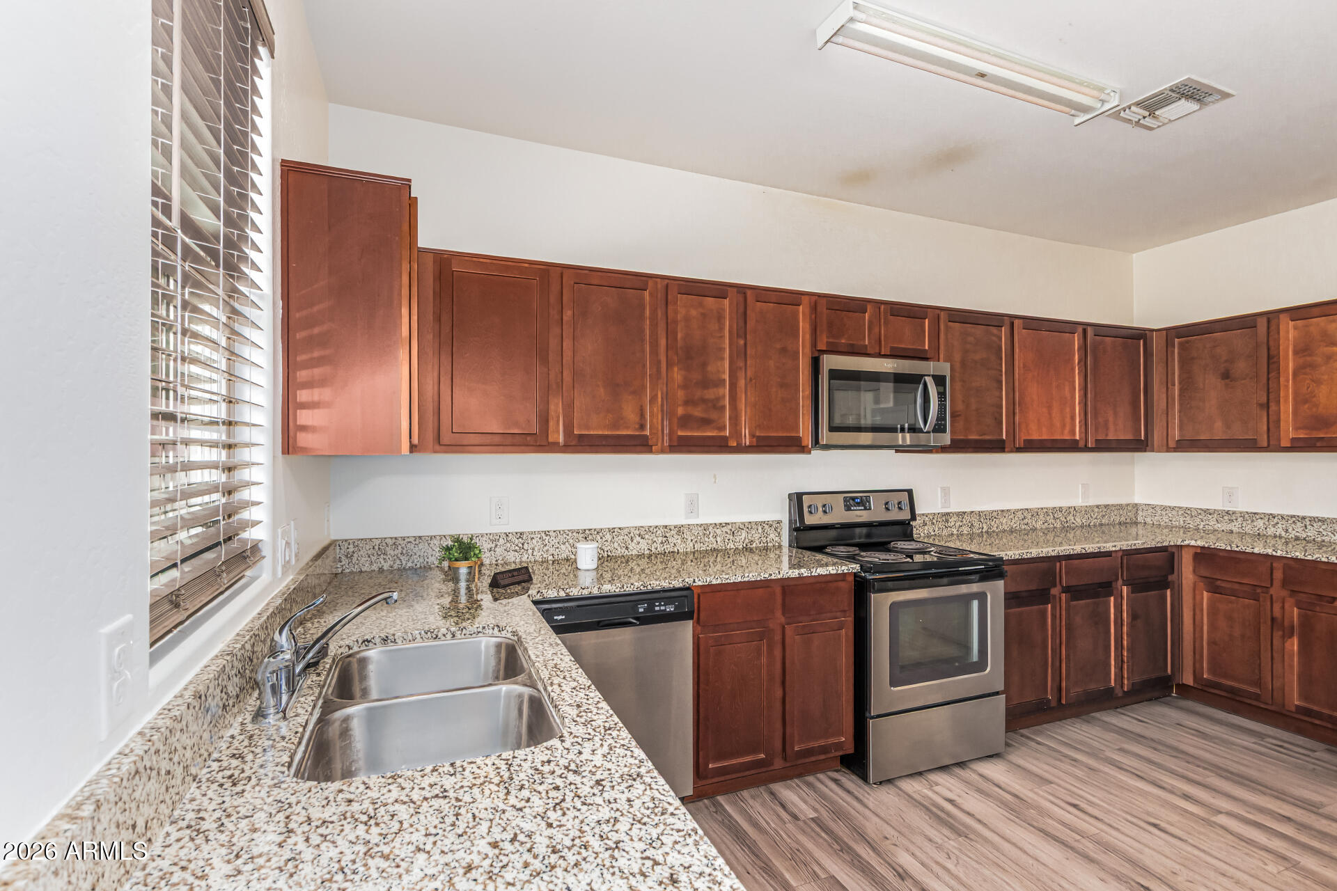 5446 Fulton Street Phoenix, AZ 85043 - Photo 15 of 42 a kitchen with stainless steel appliances granite countertop sink stove top oven and cabinets