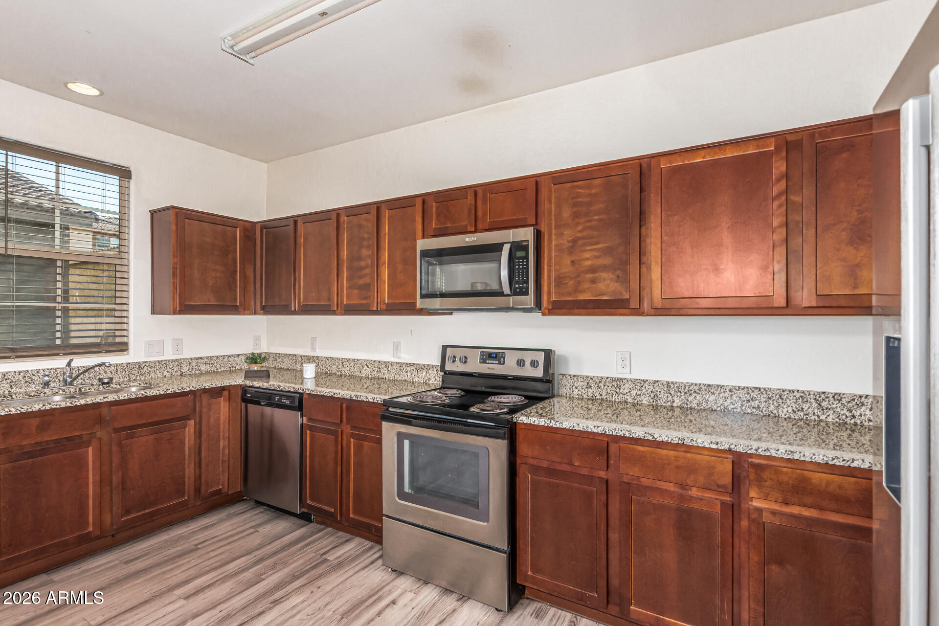 5446 Fulton Street Phoenix, AZ 85043 - Photo 16 of 42 a kitchen with stainless steel appliances granite countertop wooden cabinets a stove a sink and dishwasher