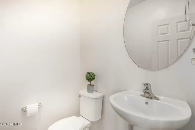a bathroom with a sink mirror and toilet