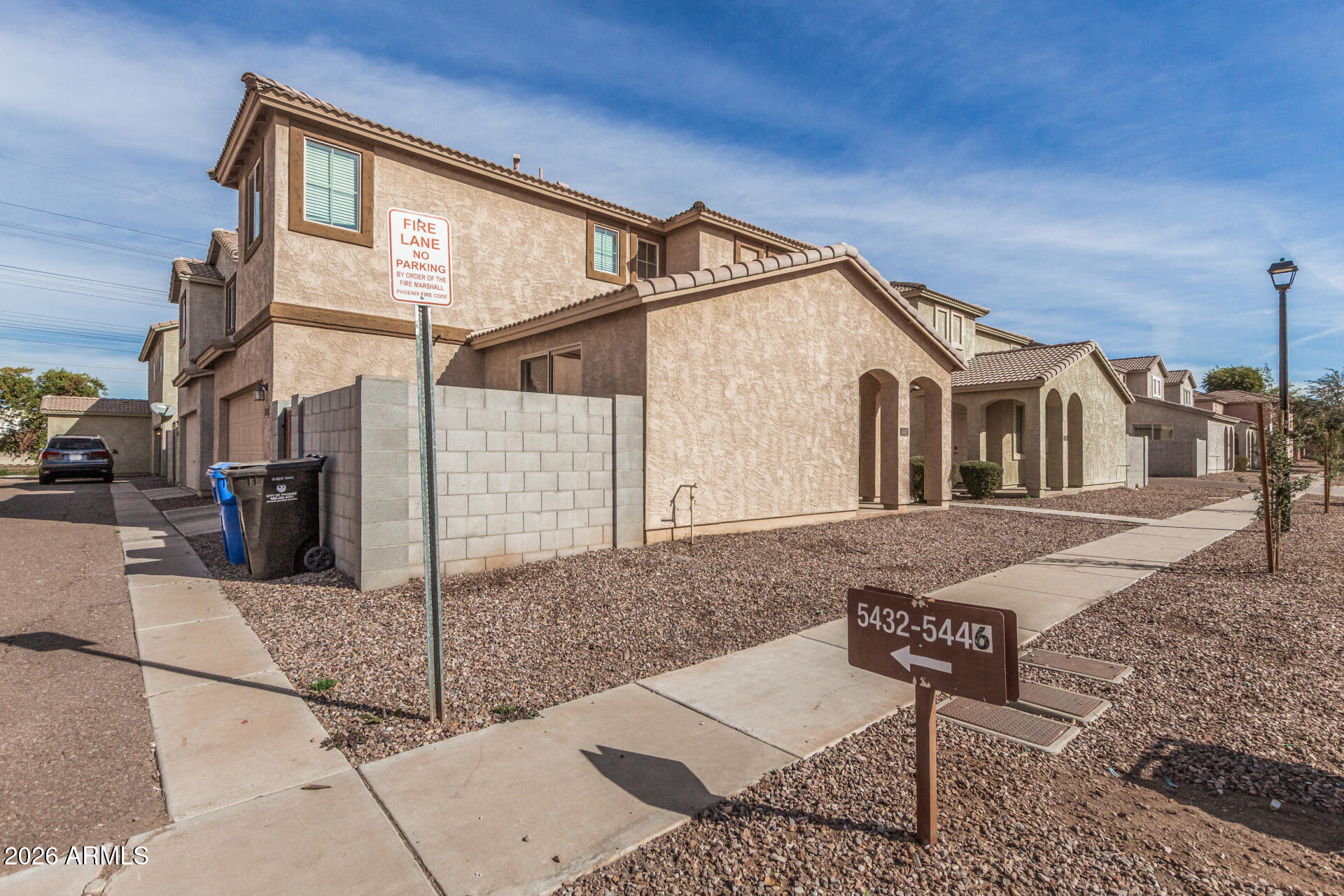 5446 Fulton Street Phoenix, AZ 85043 - Photo 41 of 42 a view of a white house with a bench and lawn chairs
