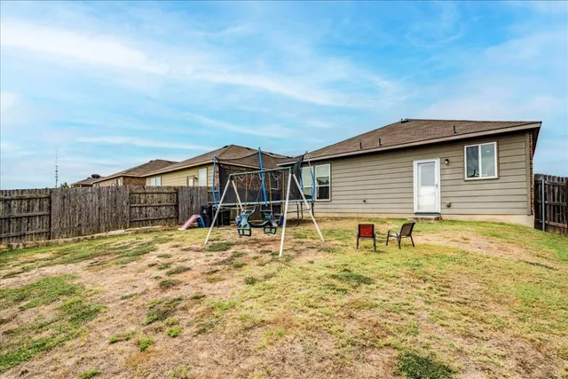 a backyard of a house with table and chairs