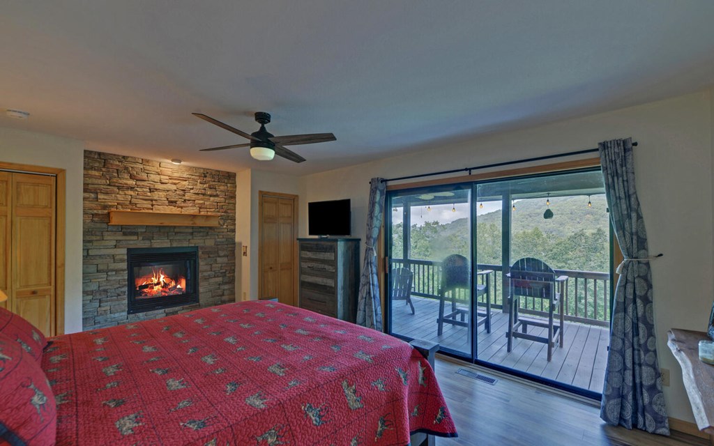 445 Tranquil Cove Road Murphy, NC 28906 - Photo 20 of 77 a bedroom with a bed and a fireplace