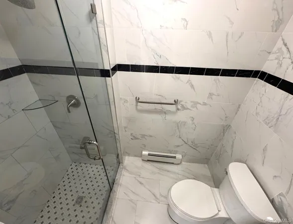 a bathroom with a toilet and a shower