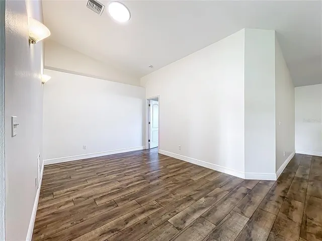 a view of a hallway with wooden floor and a potted plant