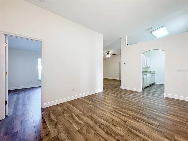 a view of empty room with wooden floor