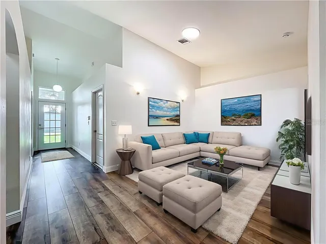 a living room with furniture wooden floor and a large window
