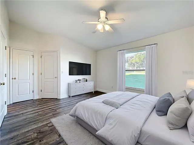 a bedroom with a bed window and a flat screen tv