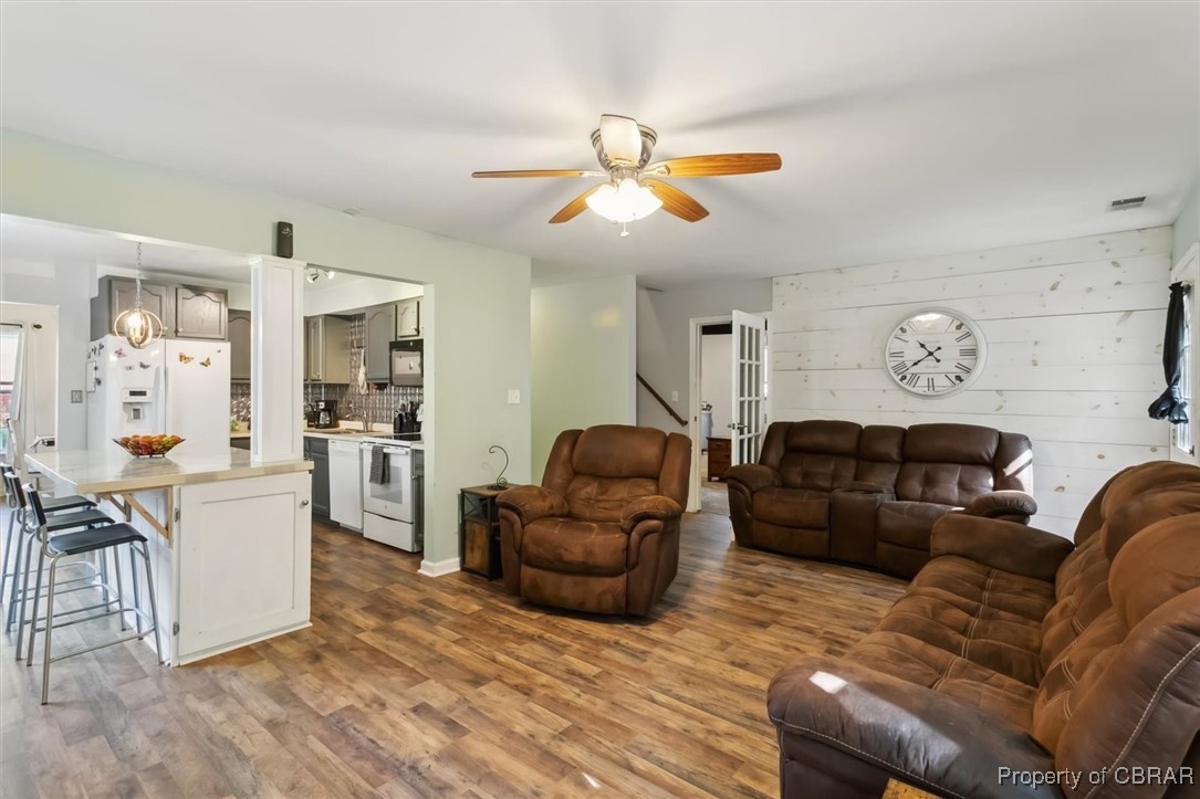 127 Low Ridge Road Williamsburg, VA 23185 - Photo 13 of 35 Living area featuring ceiling fan, visible vents, stairway, wood finished floors, and wood walls