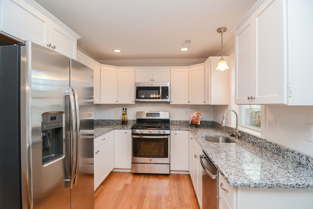 1400 Gorham Street, Unit 40 Lowell, MA 01852 - Photo 5 of 19 a kitchen with stainless steel appliances granite countertop a refrigerator a stove and a sink
