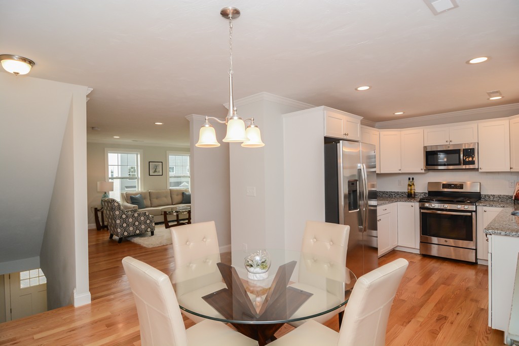 1400 Gorham Street, Unit 40 Lowell, MA 01852 - Photo 7 of 19 a view of a dining room and livingroom with furniture wooden floor a chandelier
