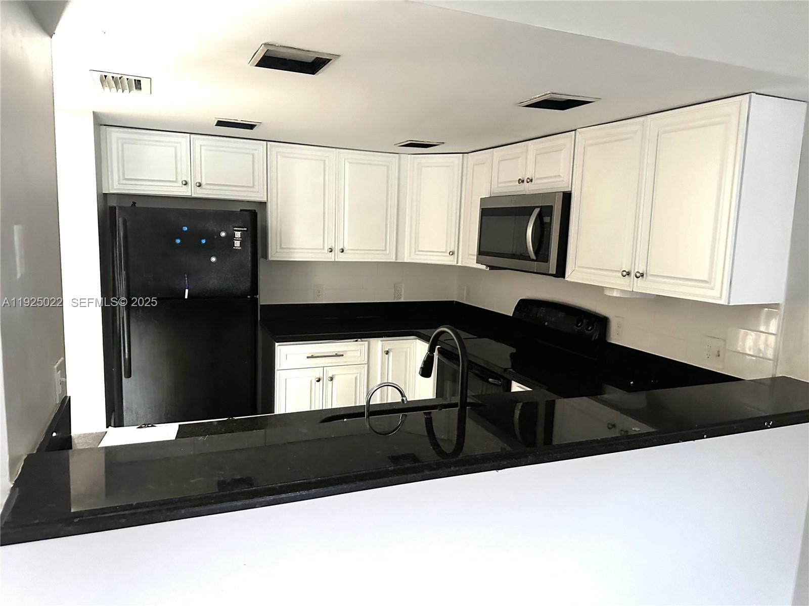 4220 Southwest 71st Terrace Davie, FL 33314 - Photo 10 of 16 a kitchen with a sink a microwave and cabinets