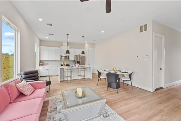 a living room with furniture and view of kitchen