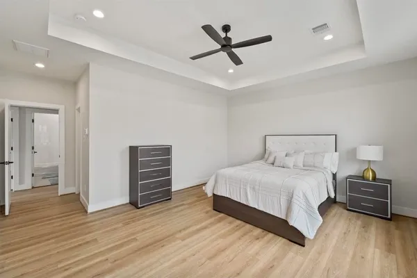 a bedroom with a bed and wooden floor