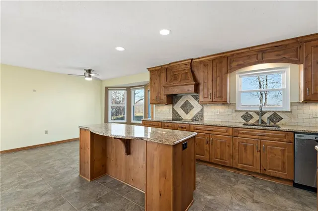 a kitchen with stainless steel appliances granite countertop a sink and a stove