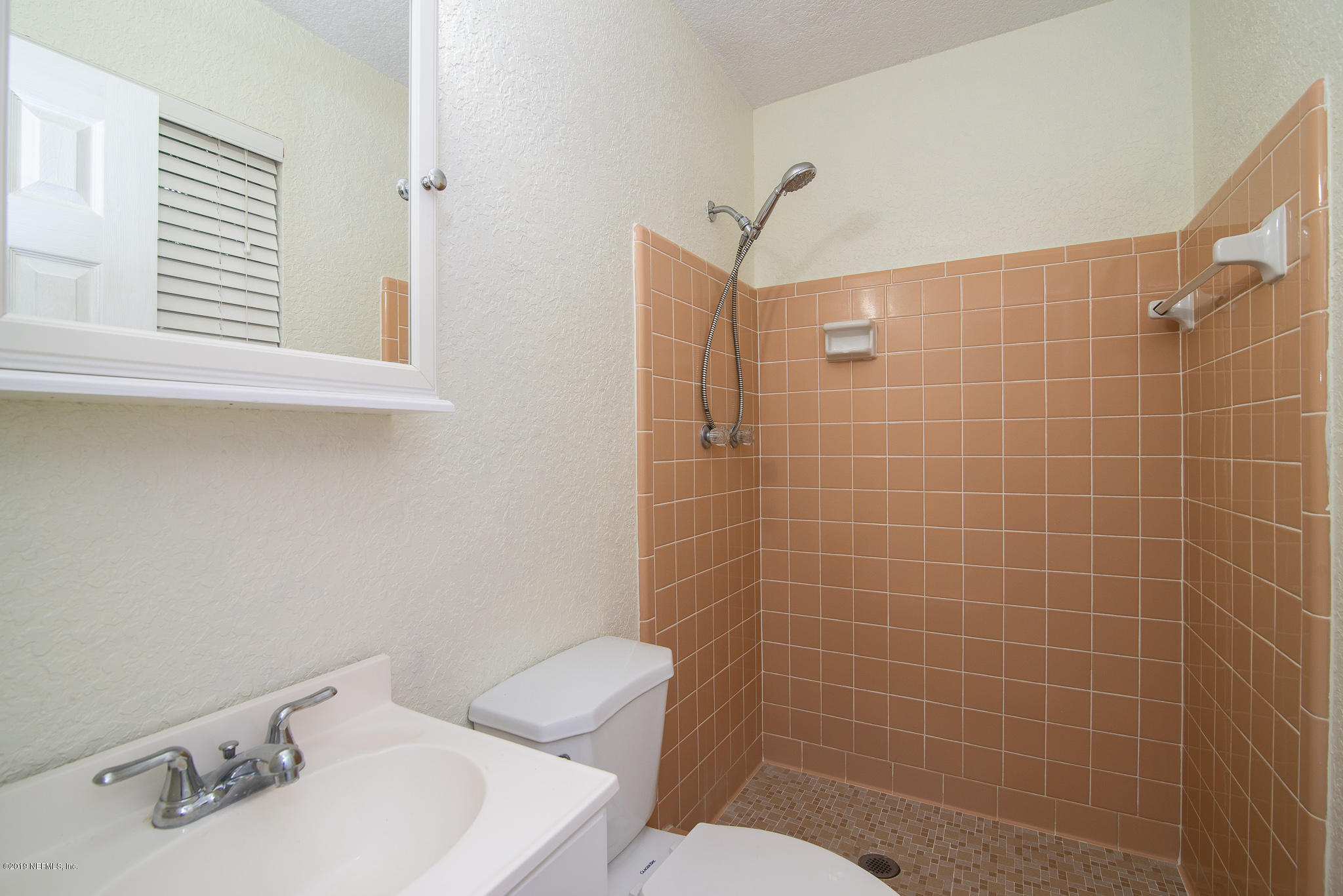 480 Irex Road Atlantic Beach, FL 32233 - Photo 15 of 26 a bathroom with a sink a toilet and a mirror
