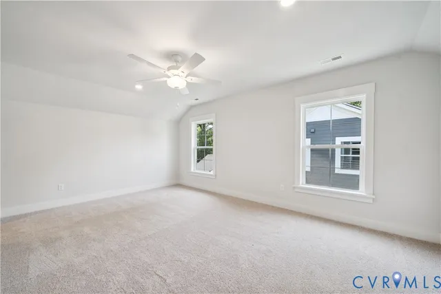 an empty room with a window and a ceiling fan